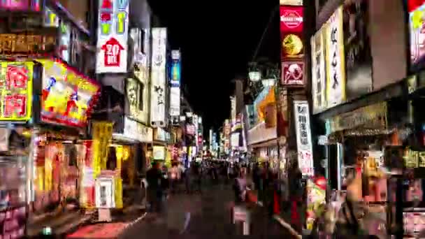 도쿄 - 신주쿠에서의 바쁜 야간 생활의 과소비. 화려 한 깃발 과 사람들이 있는 거리. 4K 해상도. — 비디오