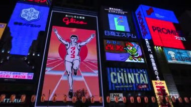 Osaka - Meşhur Glico gece parlayan reklam panosu koşucusu. 4K çözünürlük zaman aşımı. Dotonbori.