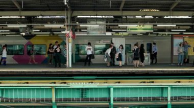 Tokyo-Nakano istasyonu peronunda tren bekleyen insanlar var. 4K çözünürlüğü