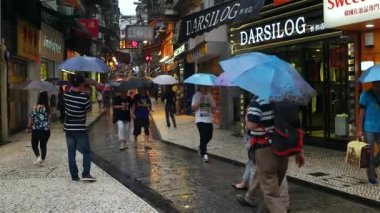 Macao - yağmurlu günlerde Macao Tarih Merkezi 'nde şemsiyeli insanlar yürüyor. 4K çözünürlüğü