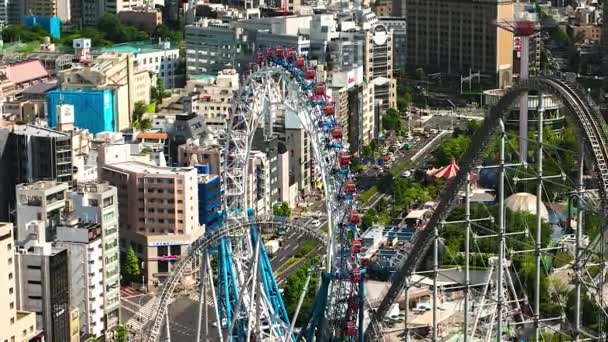 Tokyo - Aerial view of city with ferris wheel, amusement park and traffic. 4K resolution time lapse zoom out. — Stock Video