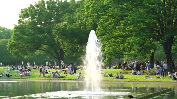 Токио - май 2016: Собрание людей в парке Ёёги в воскресенье днем у озера с фонтаном. Разрешение 4K — стоковое видео