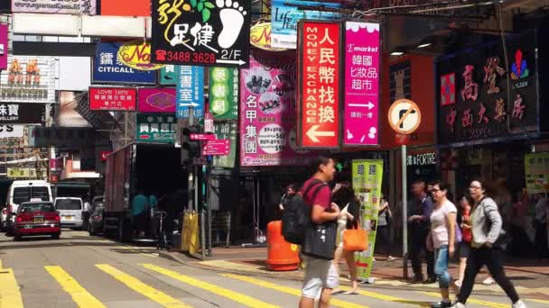 HONG KONG - Människor korsar shoppinggatan med färgglada skyltar. 4K-upplösning. — Stockvideo