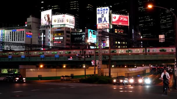 東京-新宿で輝く看板列車や交通と夜の街の景色。4K解像度 — ストック動画