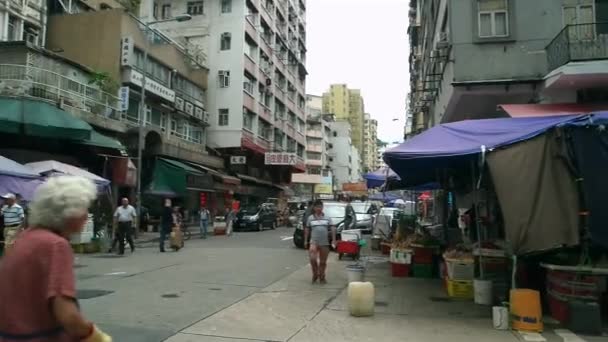 Hong Kong - Kowloon caddesi manzaralı kavşakta insanlar ve pazar var. Yavaş çekimde döndürme. — Stok video