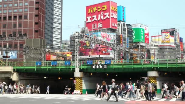 Tóquio, Pessoas na passarela com outdoors coloridos no fundo, trem e tráfego. Shinjuku. Resolução 4K — Vídeo de Stock