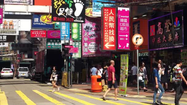 HONG KONG - Ludzie przechodzący przez ulicę handlową z kolorowymi tablicami. Rozdzielczość 4K. — Wideo stockowe