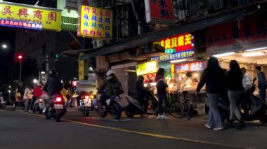 Taipei - Yemek tezgahları, parlayan tabelalar, insanlar ve trafik olan akşam sokak manzarası. 4K çözünürlüğü