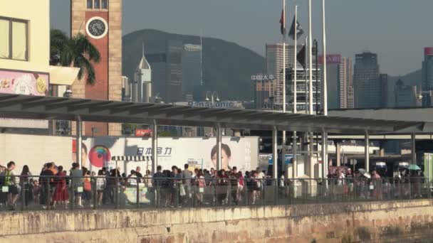 Hong Kong - Gente caminando en el paseo marítimo en el muelle Tsim Sha Tsui. Kowloon. Resolución 4K — Vídeos de Stock