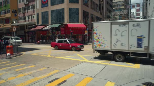 Hongkong - Street view of small junction with traffic and people on crosswalk. Kowloon Ordförande. — Stockvideo