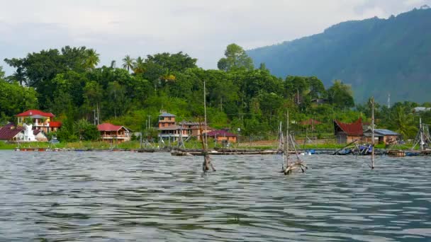 Lago Toba com gaiolas de pesca e aldeia no fundo. Resolução 4K . — Vídeo de Stock