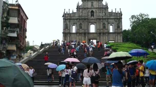 マカオ-聖パウロ教会の有名な遺跡の前に傘を持つ人々 — ストック動画
