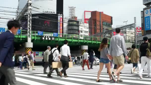 Tokio - Mensen op kruispunt met verkeer en treinen passeren. Shinjuku. 4K resolutie versnellen. — Stockvideo