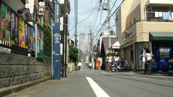 東京-高層ビルを背景にした小さな静かな車線や人々が歩いてサイクリング。4K解像度 — ストック動画