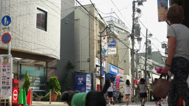 Tokio - Pequeño carril tranquilo con gente caminando y en bicicleta. Resolución 4K — Vídeo de stock