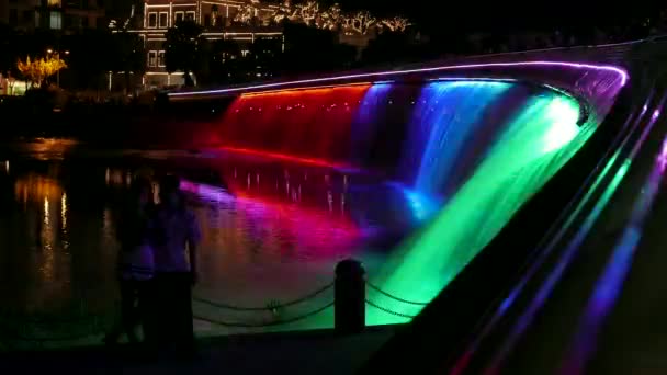 Ho Chi Minh City - Kleurrijke waterval 's nachts met silhouetten van mensen, Starlight brug. 4K-resolutieverjaring. — Stockvideo