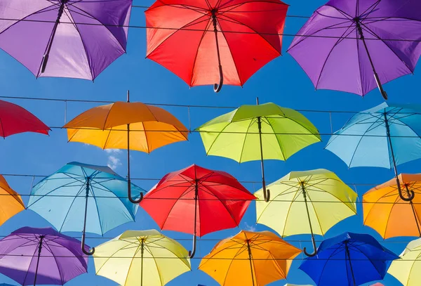 Many multi-colored umbrellas in the blue sky