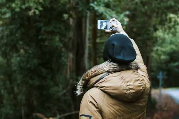 Мальчик с мобильным телефоном на природе — стоковое фото
