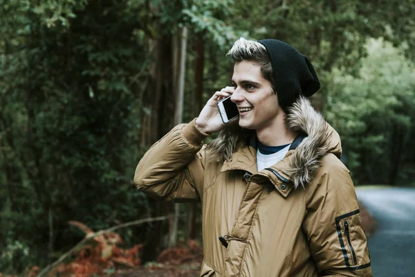 Jongen met de telefoon mobiel in de natuur — Stockfoto