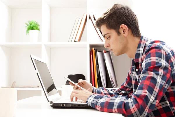 Homem com celular e laptop — Fotografia de Stock