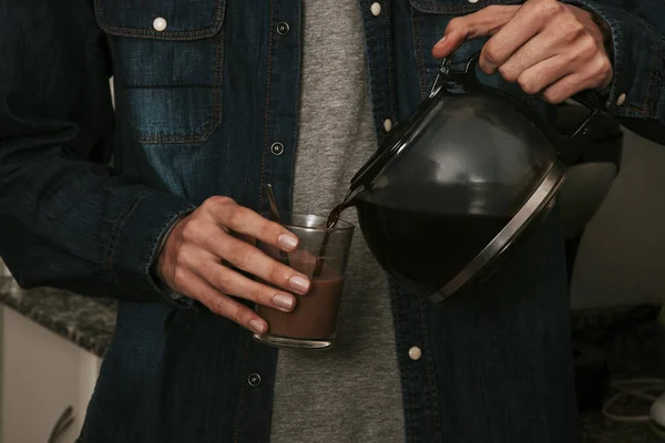 Coffee pot pouring coffee into cup — Stock Photo, Image