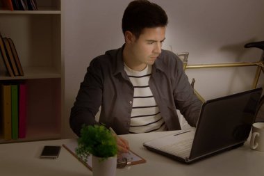 Adam evde ders çalışıyor. 