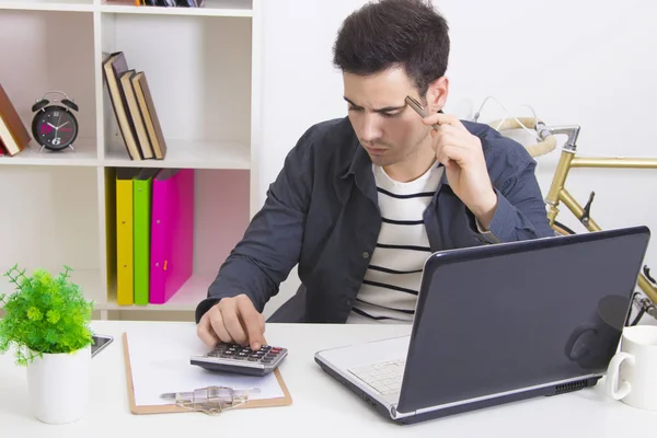 Mann mit Taschenrechner und Laptop — Stockfoto