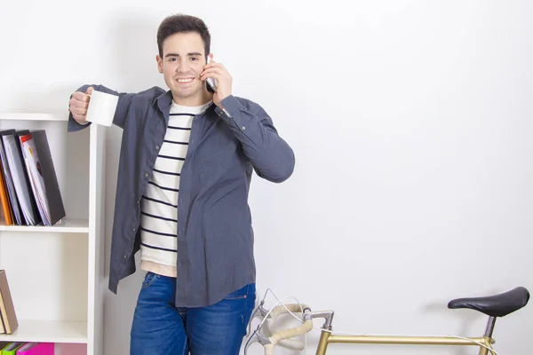 Jovem em casa com seu celular — Fotografia de Stock