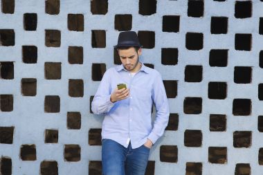 Akıllı telefonu olan genç bir adam.