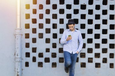 Akıllı telefonu olan genç bir adam.