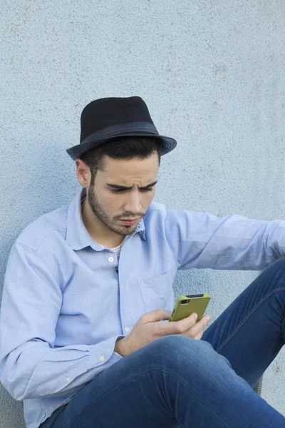 Man met mobiele op muur — Stockfoto