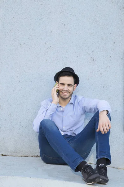 Hombre con móvil en la pared — Foto de Stock