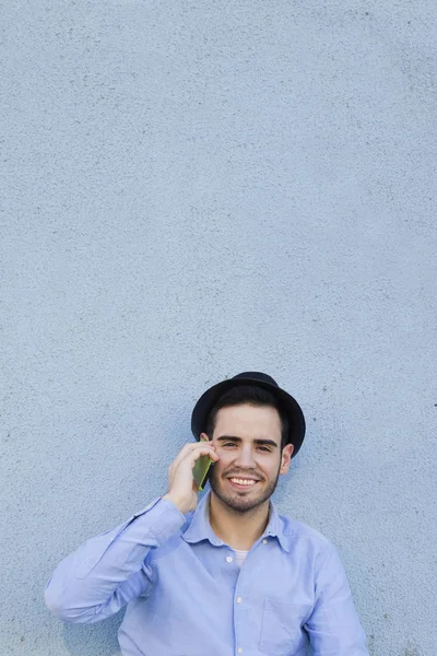 Man met mobiele op muur — Stockfoto