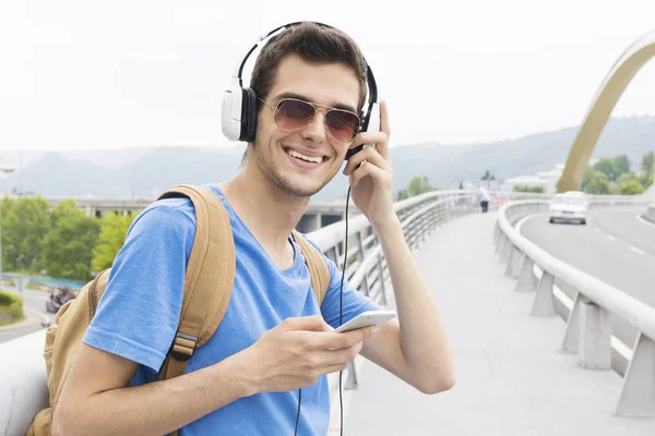 Joven escuchando música en la calle — Foto de Stock