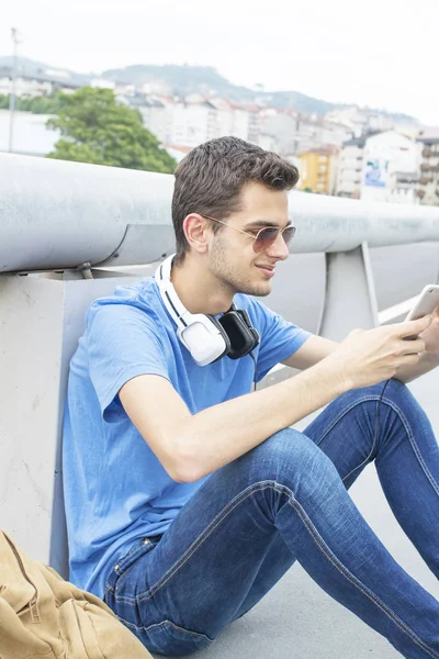 Young man listening to music on the street — Stock Photo, Image