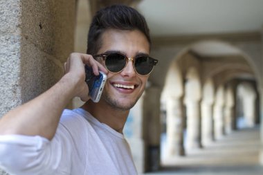 genç gülümseyen cep telefonu üzerinde konuşurken adam