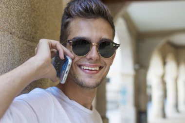 cep telefonu üzerinde konuşurken sokakta genç