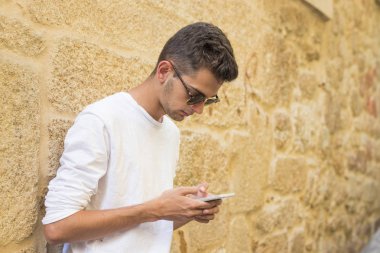 şehir içinde hareket eden telefon ile genç gülümseyen portresi