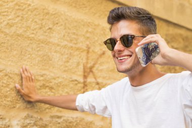 şehir içinde hareket eden telefon ile genç gülümseyen portresi