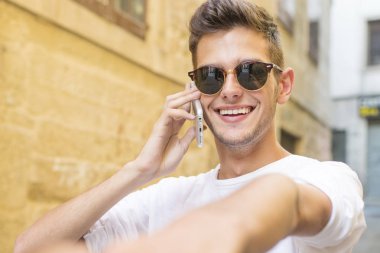 genç adam telefonda konuşurken onun elini tutarak