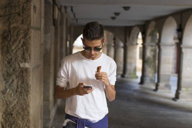 hareket eden telefon ile yürüyen genç 