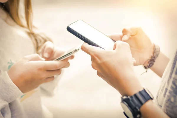 group of friends with mobile phones chatting and playing