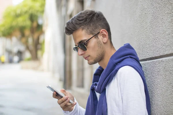 Młody człowiek z telefonem komórkowym — Zdjęcie stockowe