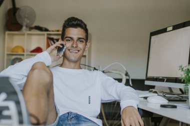 hareket eden telefon ile evde gülümseyen genç adam