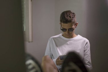 Genç odasında cep telefonu ve bilgisayar ile