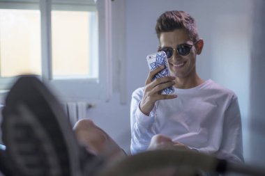 genç ya da genç adam öğrenci üstünde okul sırası ile cep telefonu ve bilgisayar