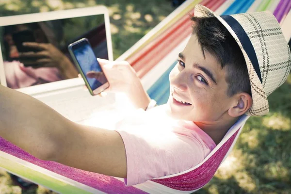夏天的吊床上有手机的孩子 — 图库照片