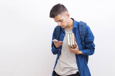 kitap ve duvar arka plan üstünde hareket eden telefon ile ergen öğrenci üniversite