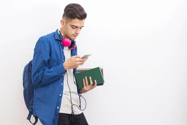 Adolescent Student Met Boeken Mobiele Telefoon Muur Achtergrond — Stockfoto