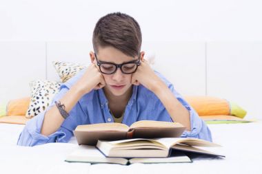 Yatak eğitim kitapları ile genç çocuk
